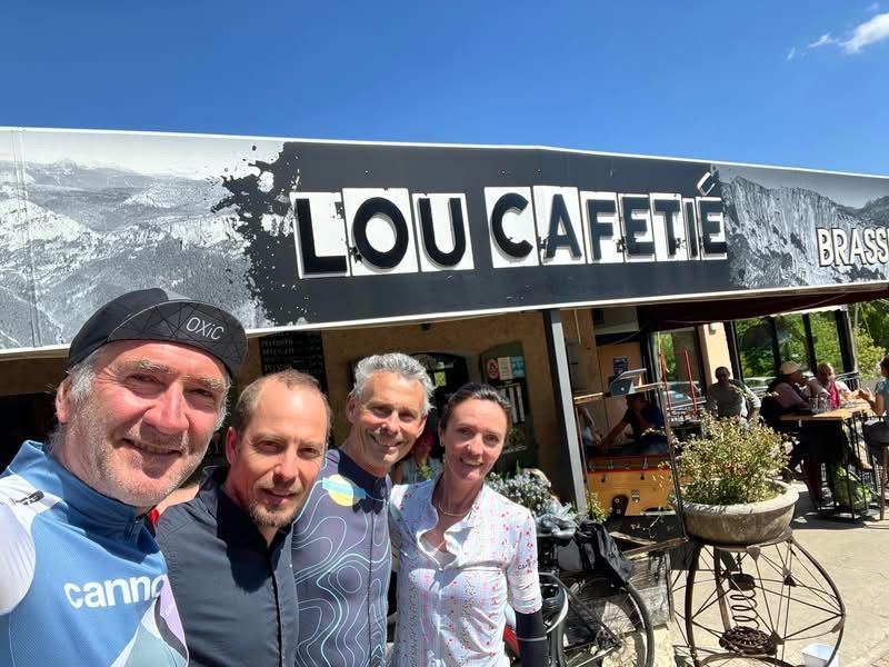 Cyclists in front of the Lou Cafetié sign