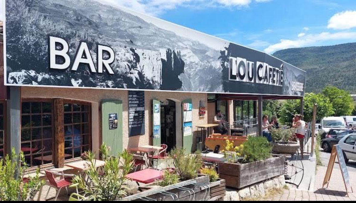 La façade du Lou Cafetié à La Palud-sur-Verdon en plein jour, sa terrasse et son baby-foot